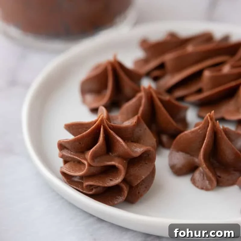 One-Bowl Chocolate Buttercream Frosting Ready in 15 Minutes 6 chocolate buttercream piped into rosettes on a white plate