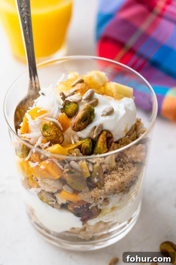 Authentic Swiss Bircher Muesli Recipe 7 a photo of tropical muesli with mango, pineapple, coconut, brown sugar, yogurt and pistachios.