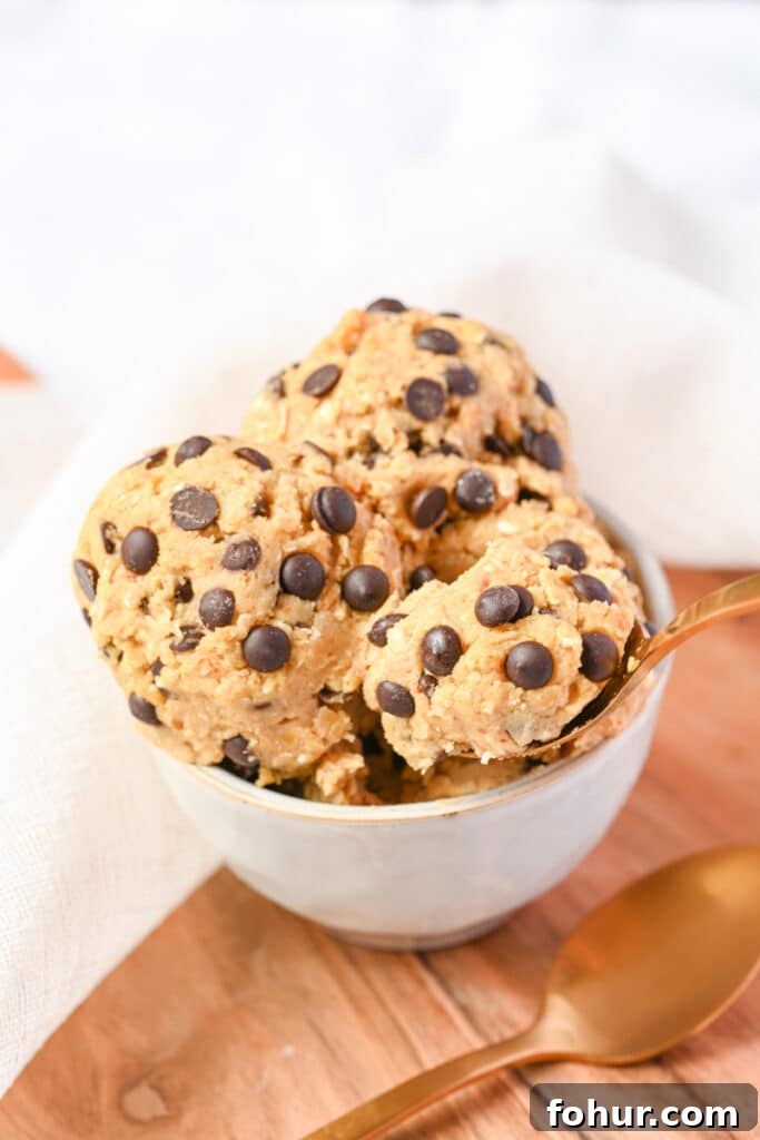 No-Bake Edible Protein Cookie Dough Recipe 11 Cookie dough with protein powder being served with a golden spoon