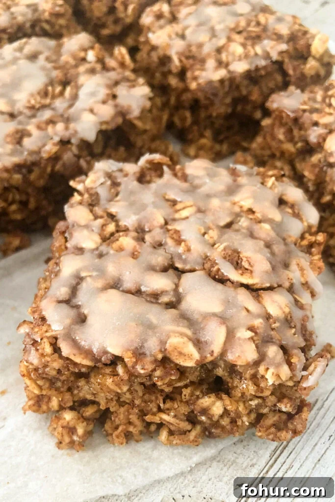 Cinnamon Roll Oatmeal with vanilla glaze drizzled on top and cut into squares