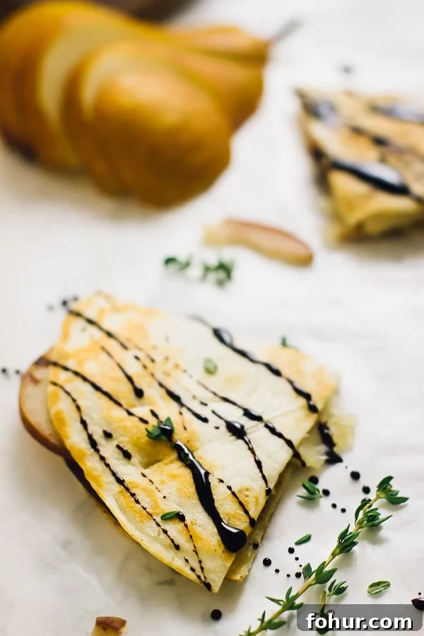 Vegan Pear and Brie Quesadilla Recipe with Caramelized Onions 4 A slice of pear brie & caramelised onions quesadilla drizzled with a balsamic glaze.