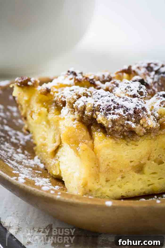 Brioche Baked French Toast with Butterscotch Sauce 2 Side shot of brioche french toast on a brown plate sprinkled with powdered sugar.