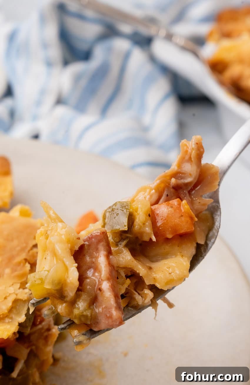 Smoked Sausage and Chicken Pot Pie Recipe with Flaky Crust 5 a silver fork holding up a scoop of smoked sausage and chicken pot pie