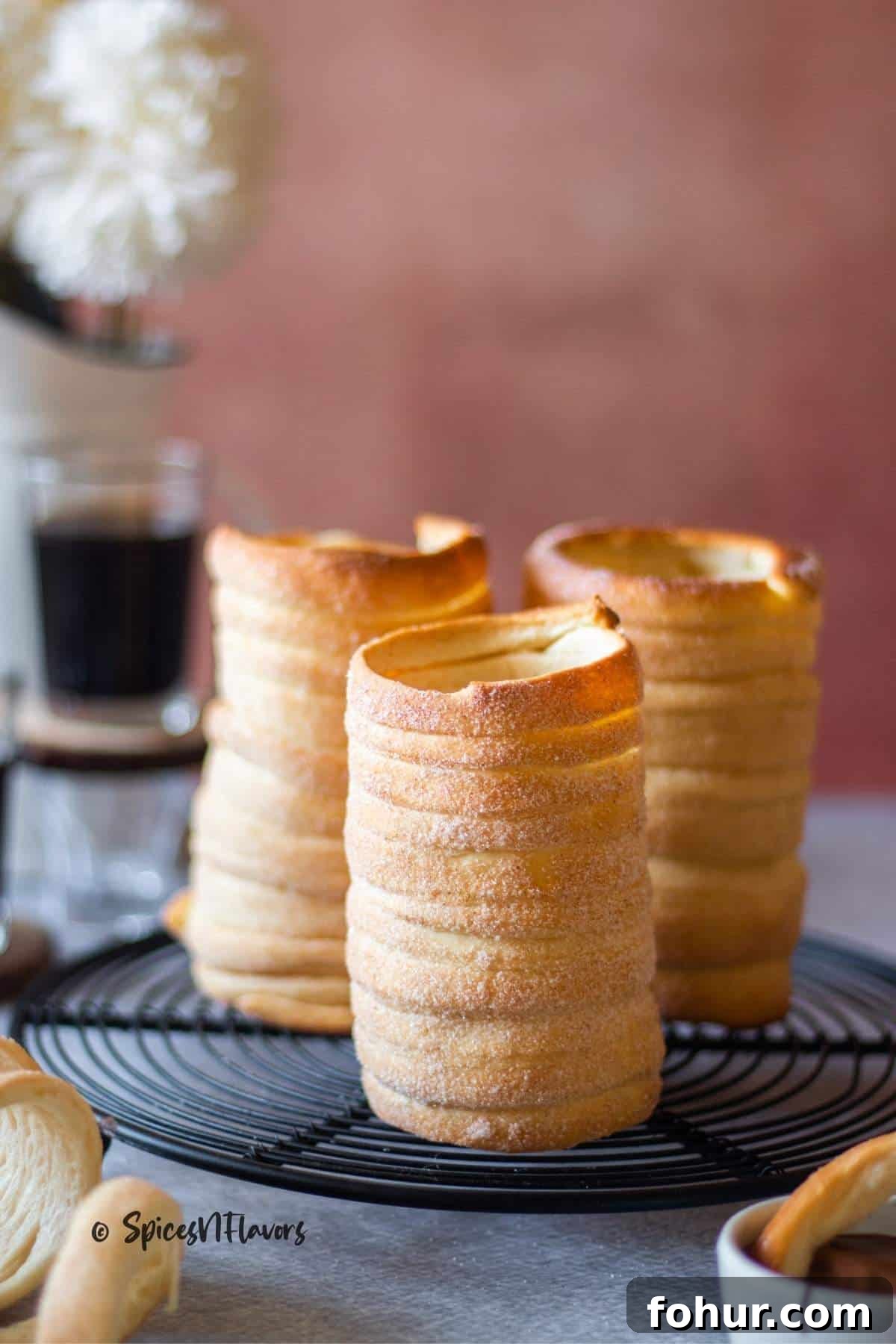 How to Make Authentic Hungarian Chimney Cake (Kürtőskalács) 9 baked chimney cakes placed upright on a wire rack to cool completely
