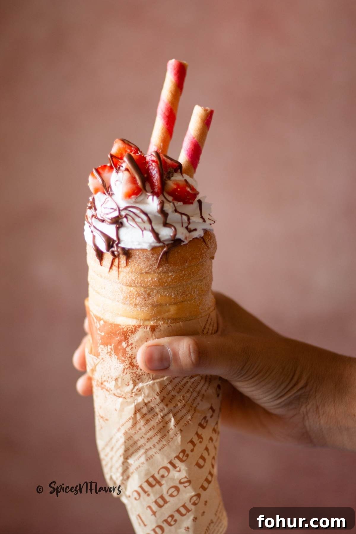 How to Make Authentic Hungarian Chimney Cake (Kürtőskalács) 11 whipped cream piped on to chimney cakes with melted chocolate and strawberries on top