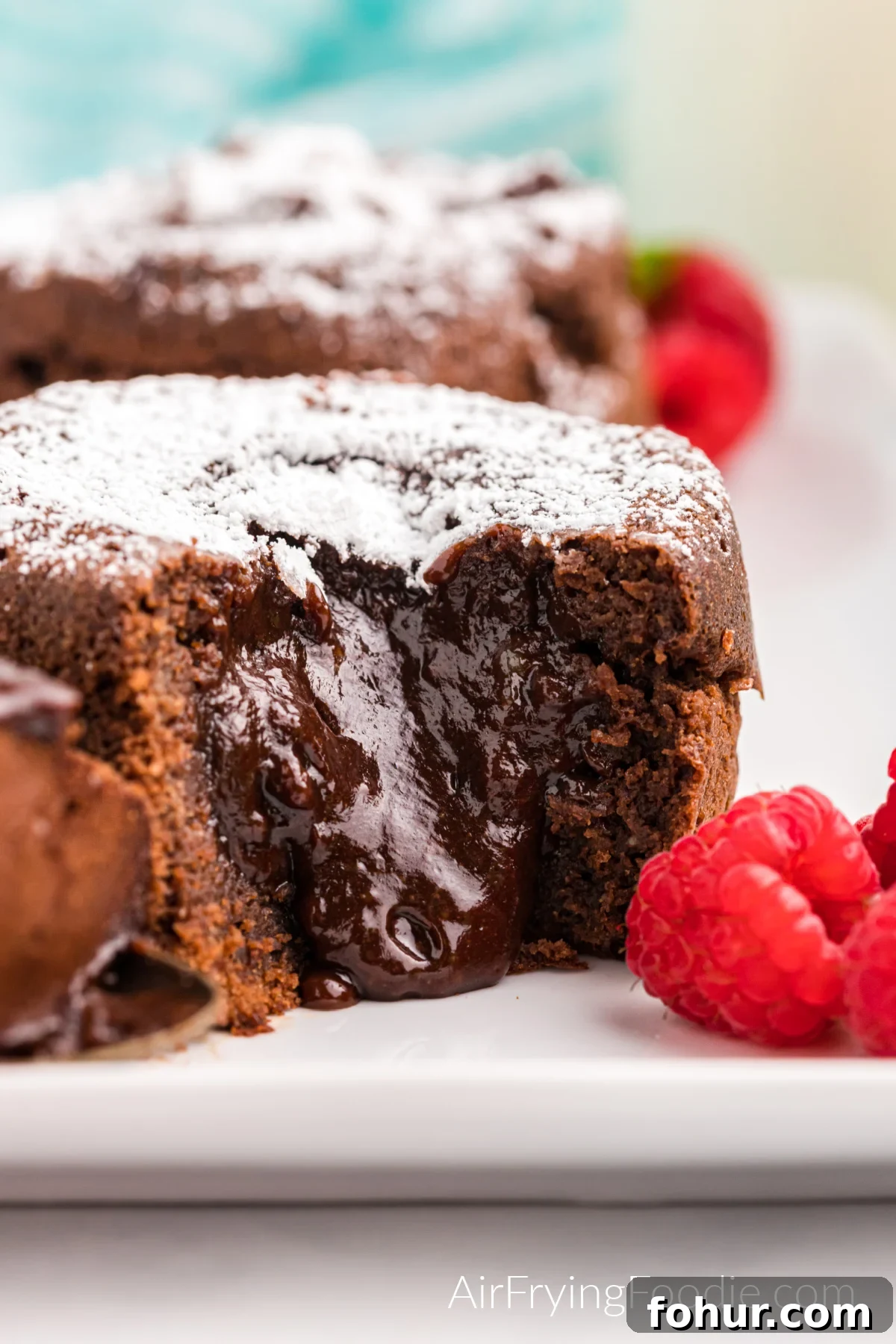 Close up of lava cake missing a bite with chocolate oozing from the center. 