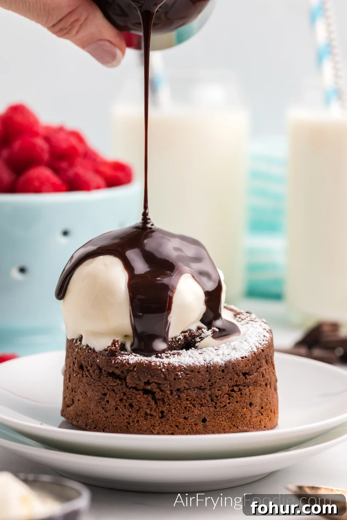 Air Fryer Lava cake topped with confectioner's sugar, ice cream, and chocolate sauce.