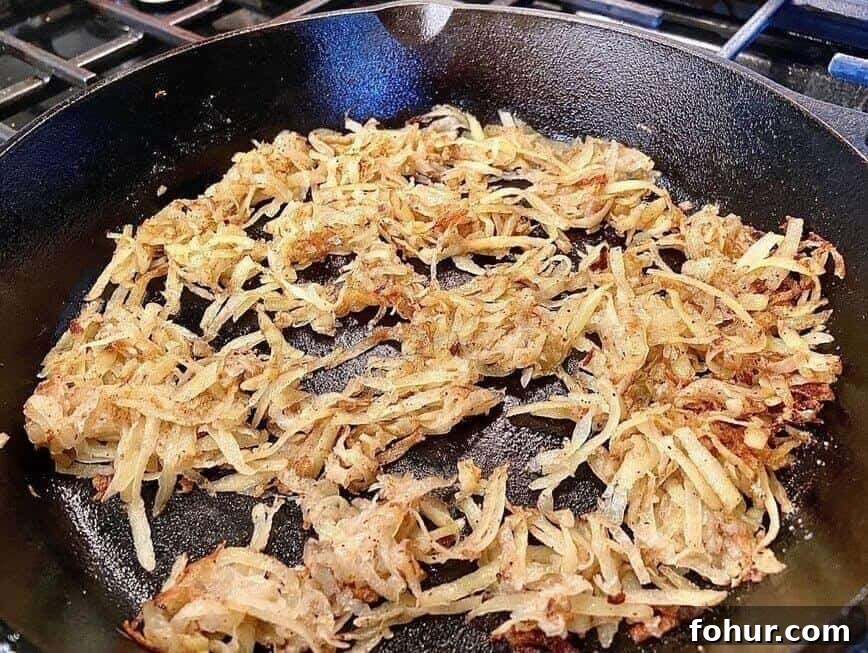 Crispy Buttery Hash Browns: How to Make Them 10 Cooking loose, shredded hash browns in cast iron pan.