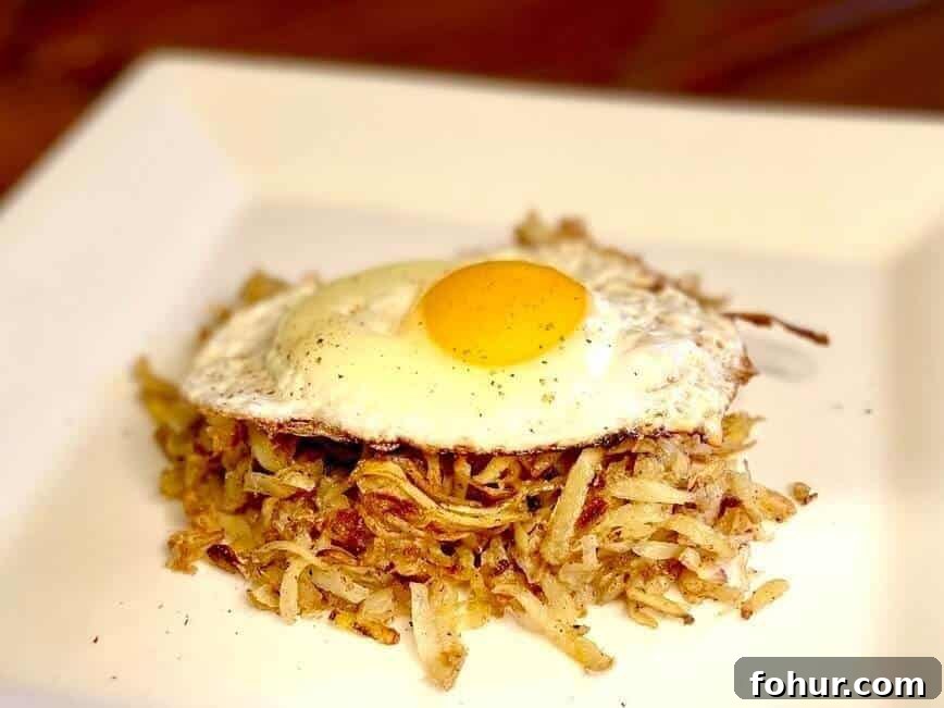 Crispy Buttery Hash Browns: How to Make Them 13 Loose shredded hash brown and egg on a white plate.