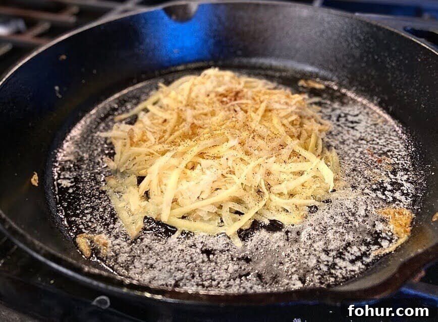 Crispy Buttery Hash Browns: How to Make Them 8 Cooking hash browns in a buttered cast iron pan.