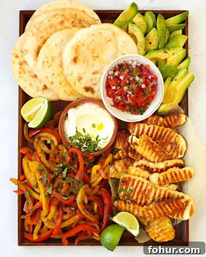 15-Minute Halloumi Fajitas with Peppers and Onions 2 Halloumi fajitas recipe on a board with tortilla wraps avocado and salsa.