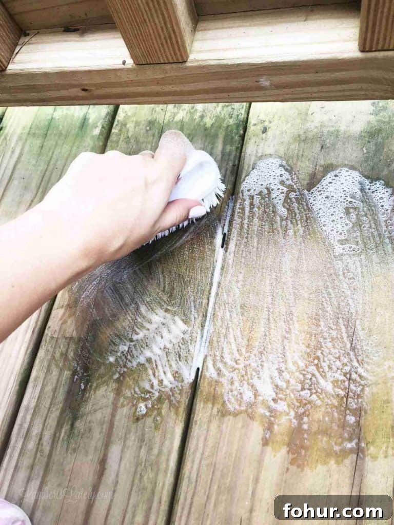 How to Remove Green Algae Stains from a Wood Deck 4 Hand scrubbing green stain off wooden deck with soap and water.