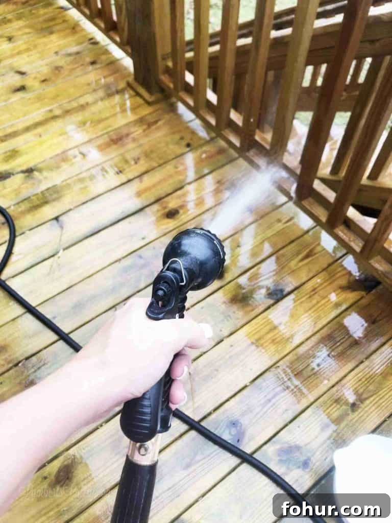 How to Remove Green Algae Stains from a Wood Deck 5 Cleaning a wooden deck with a pressure washer to remove green stains.