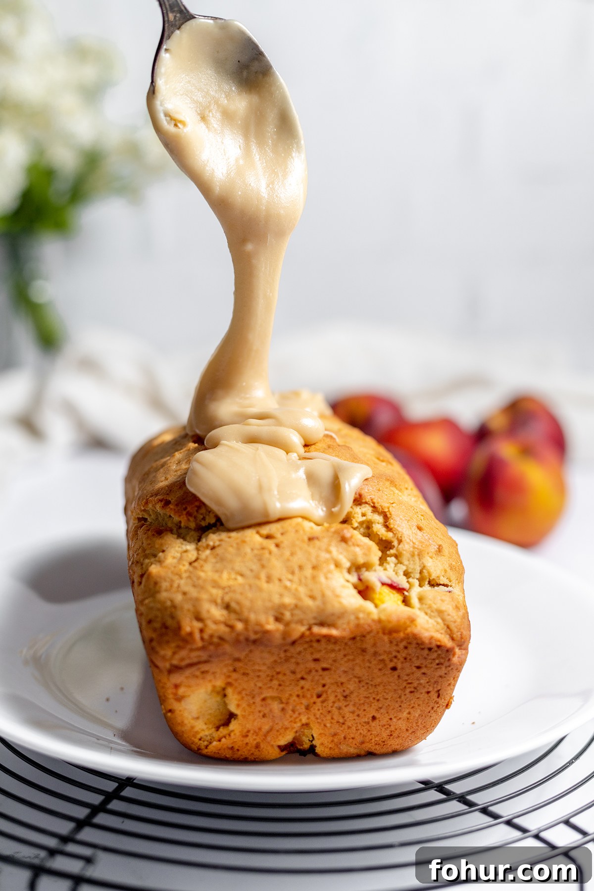 Moist Homemade Peach Bread Recipe with Cinnamon Glaze 9 Pouring Glaze over top of peach bread.