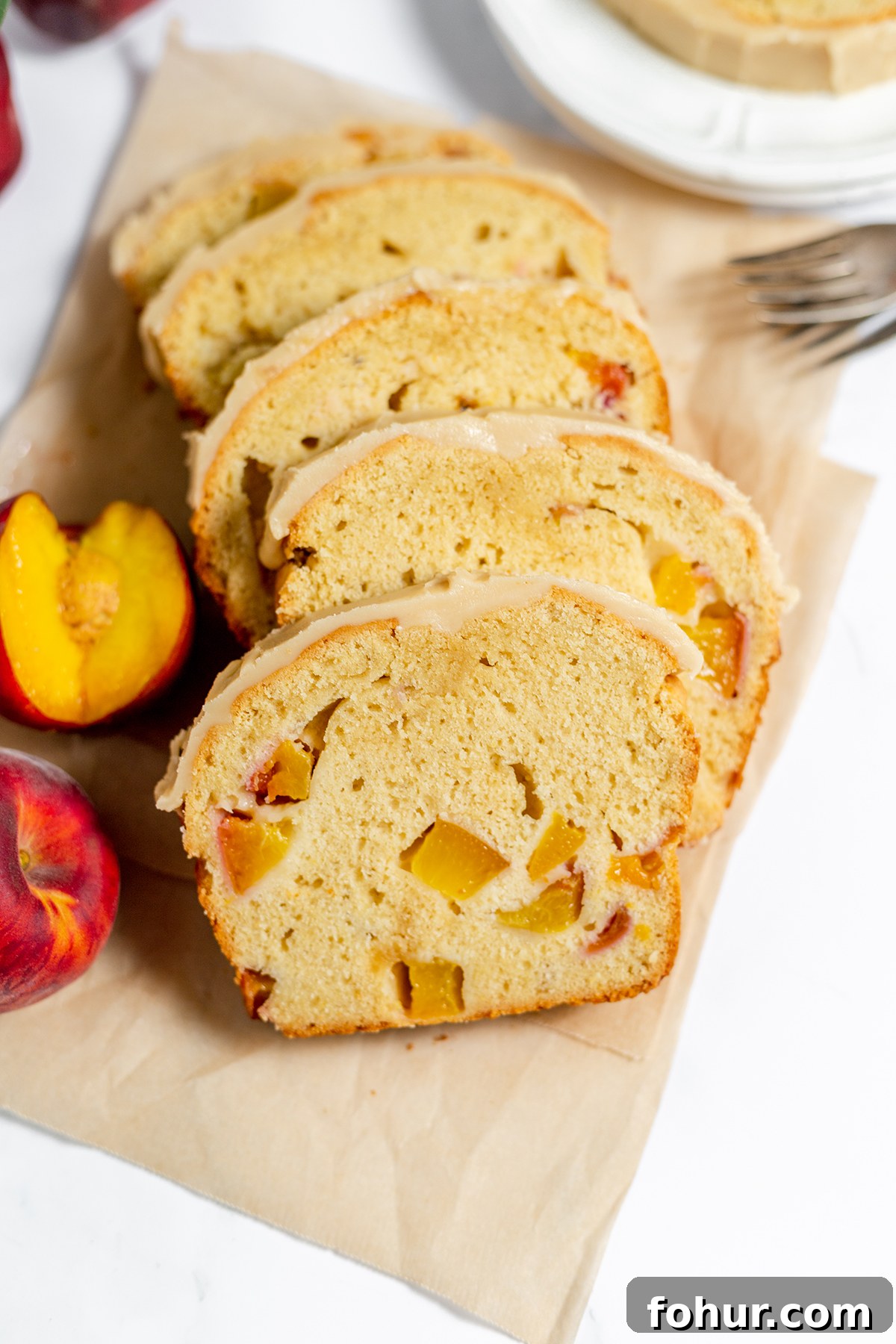 Moist Homemade Peach Bread Recipe with Cinnamon Glaze 10 5 slices of peach bread laying on parchment paper.