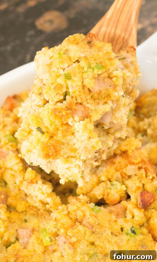 A wooden serving spoon full of cornbread stuffing