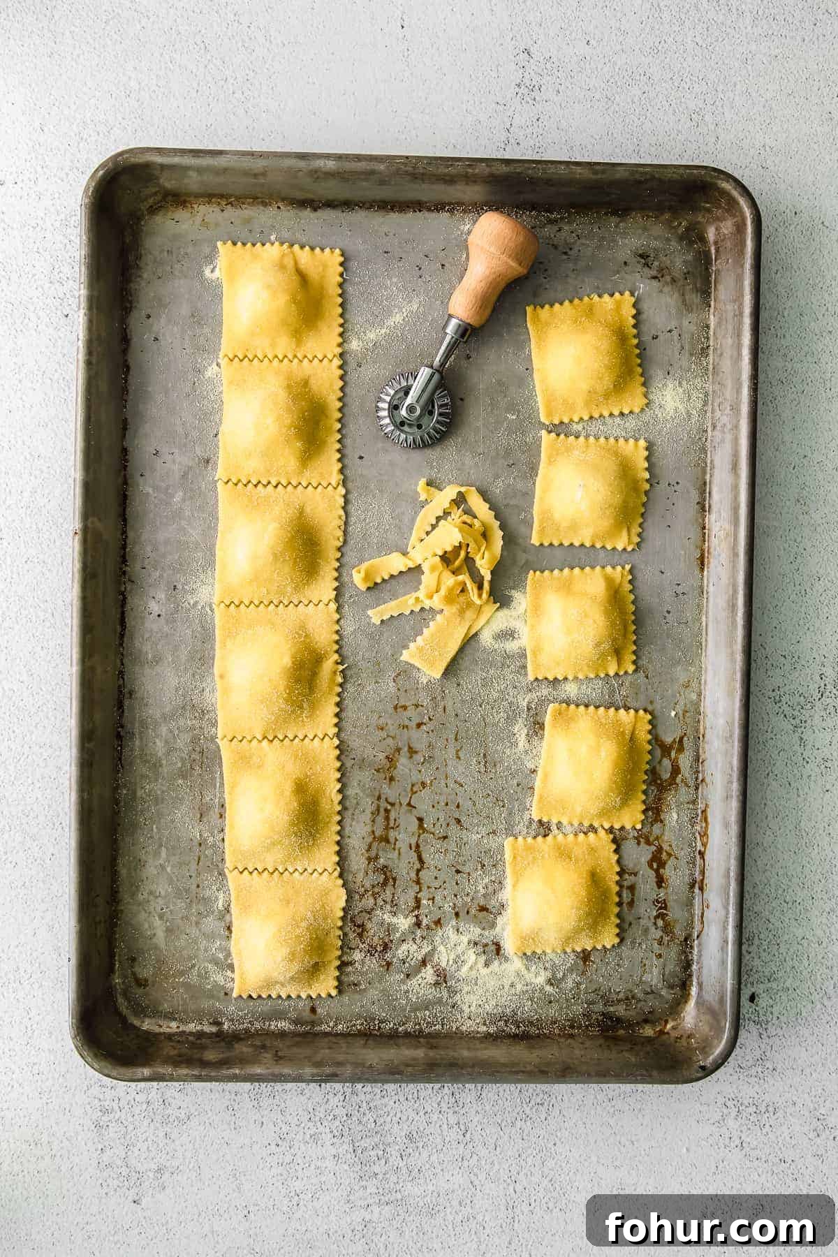 Cut homemade cheese ravioli homemade cheese ravioli cut with a pasta knife on a baking sheet