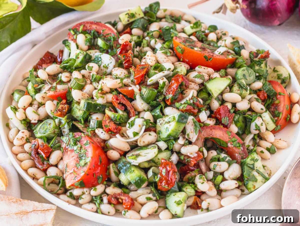 Hearty Mediterranean White Bean Salad with Herbs and Lemon 7 Step 4 Tossing white beans and veggies together until coated and ready to serve.