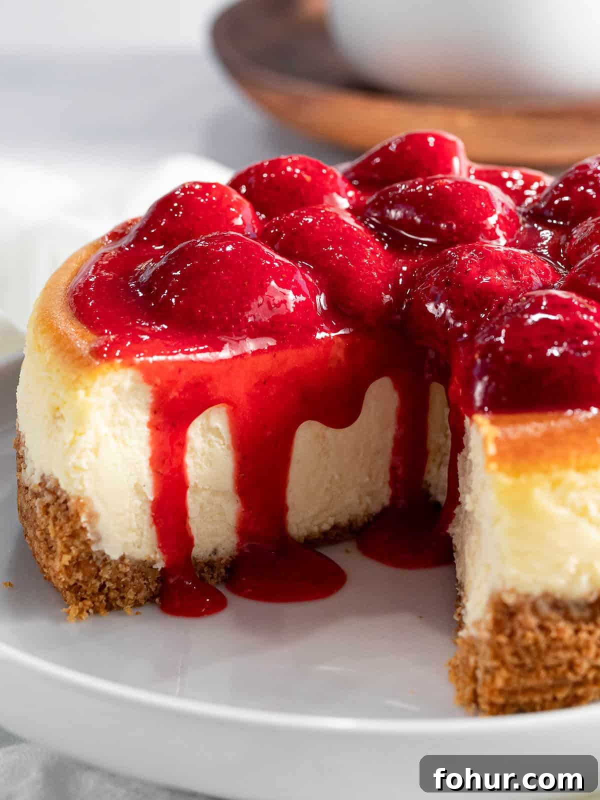 Strawberry sauce is used to glaze the top of cheesecake.
