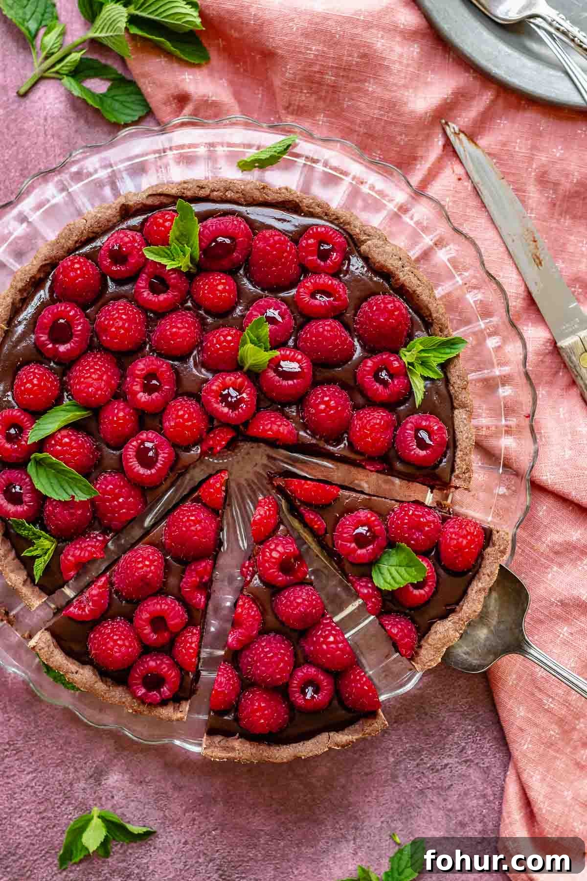 From Scratch Chocolate Raspberry Tart Recipe 10 Sliced chocolate raspberry tart on a platter.