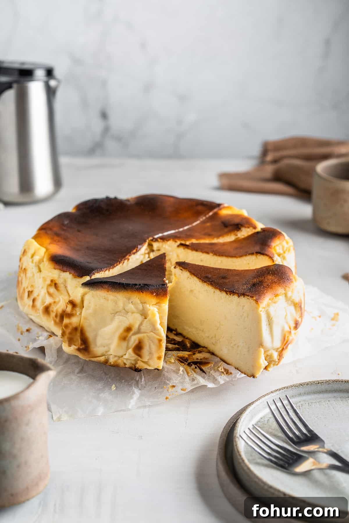 Sliced burnt Basque cheesecake on a serving plate.