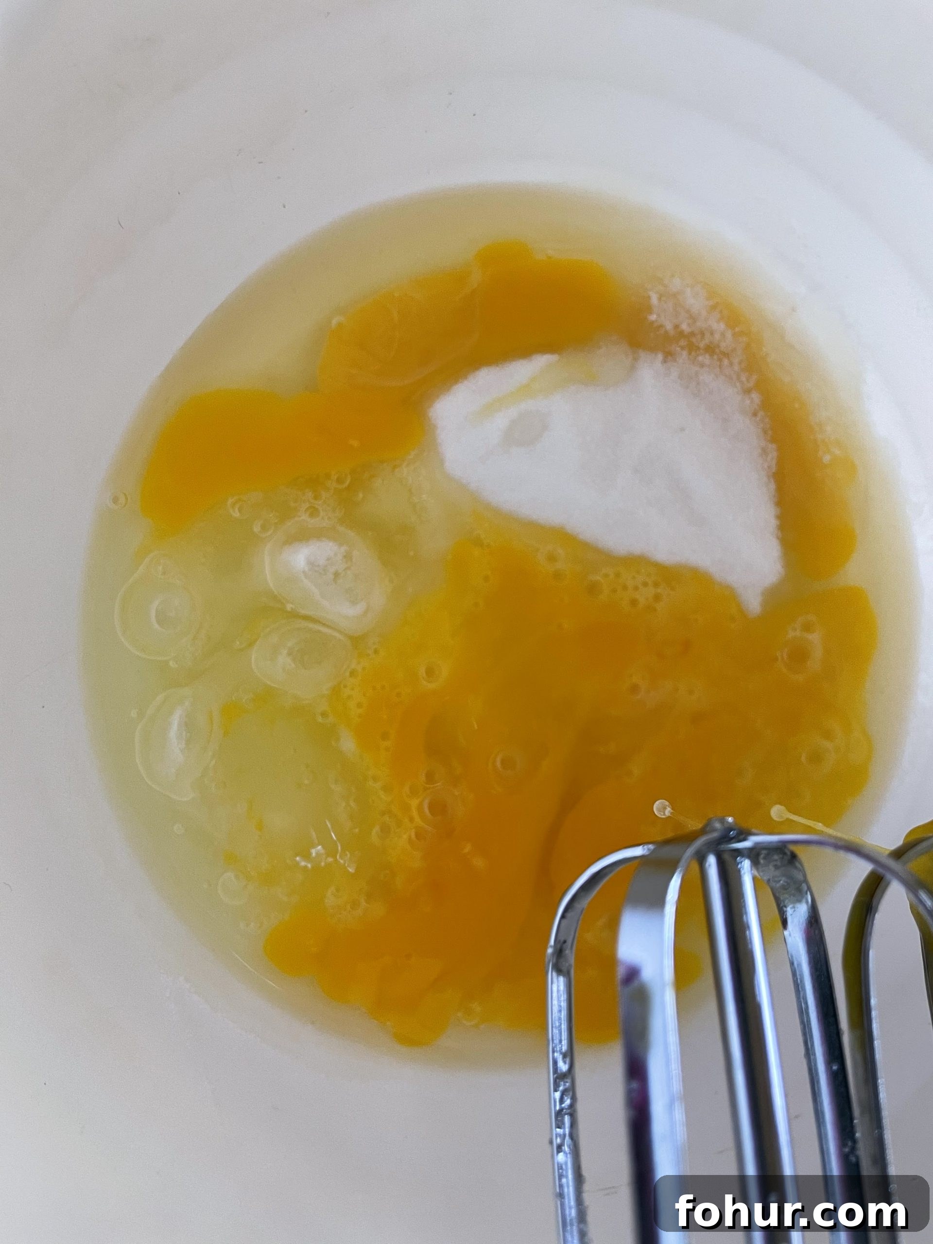 Mix sugar, eggs and extract for clafoutis Mix sugar, eggs and extract for clafoutis