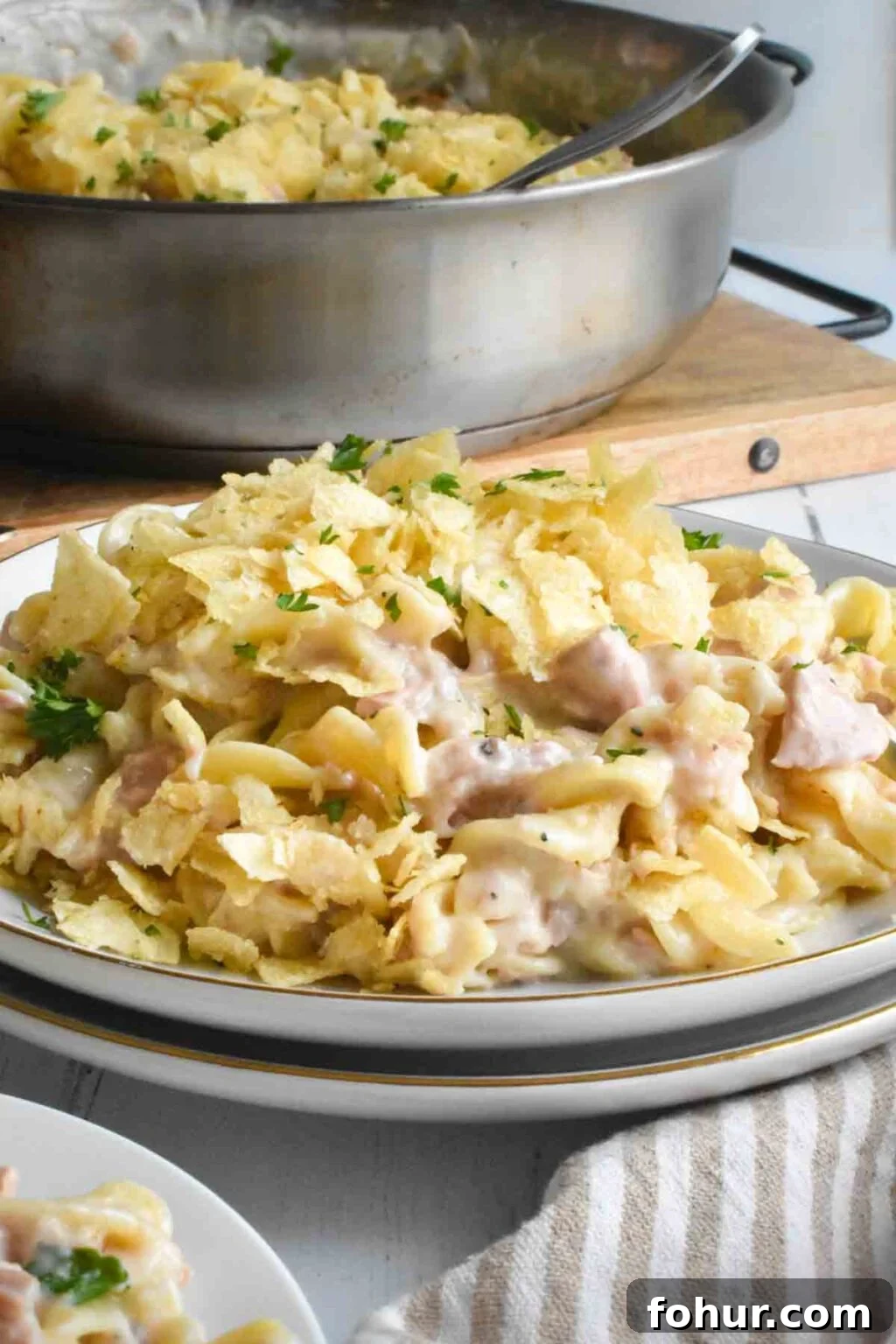 Stove-Top Tuna Noodle Casserole This is a photo of stove-top tuna noodle casserole served on a plate with the pan in the background.