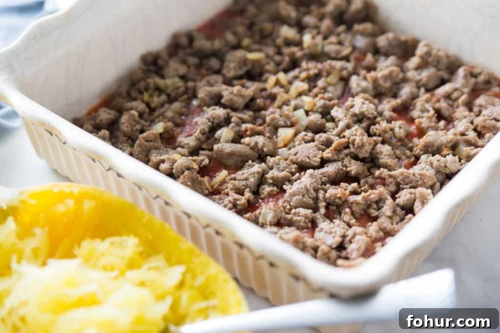 Low-Carb Spaghetti Squash Lasagna Recipe 7 A baking dish layer with sauce and ground Italian chicken sausage.