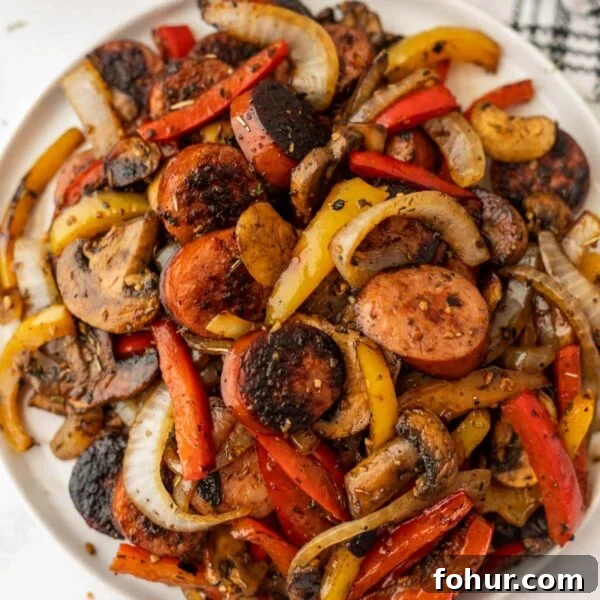 A plate of sausage, peppers and onions.