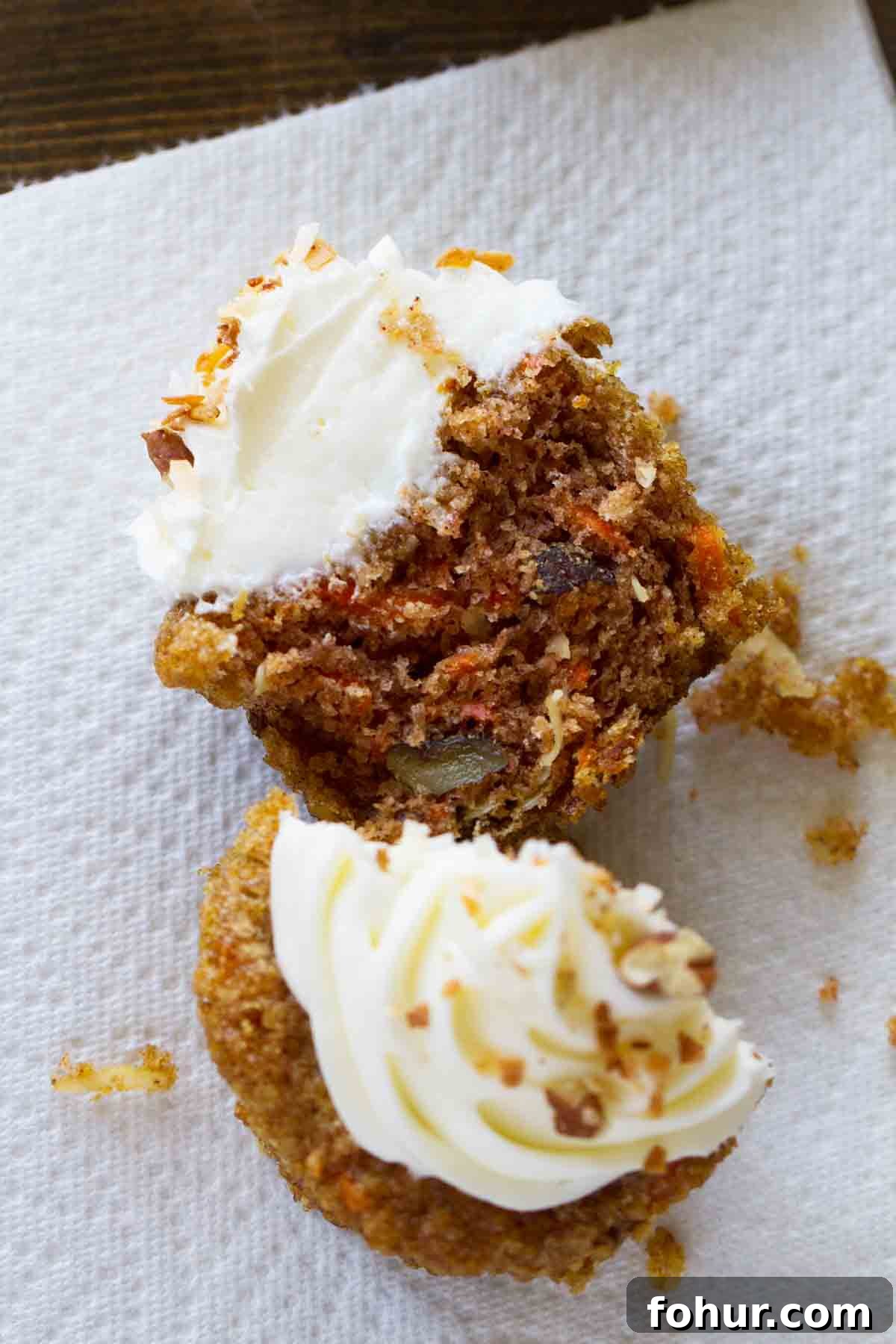 Simply the best, these Carrot Cake Cupcakes are filled with lots of carrots and coconut and are topped with a smooth and creamy cream cheese frosting. carrot cake cupcake cut in half to show interior