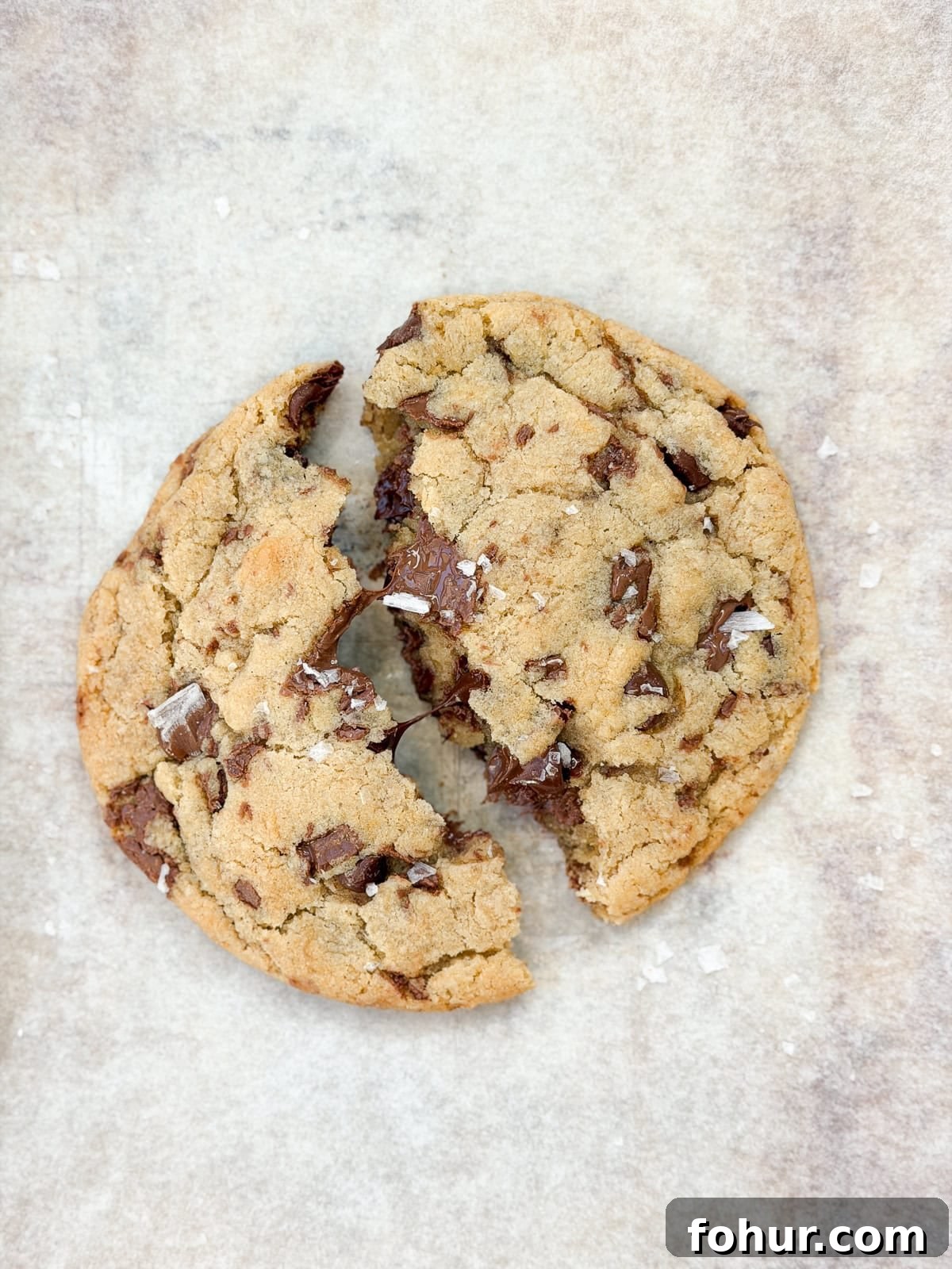 a single serve chocolate chip cookie broken in half.