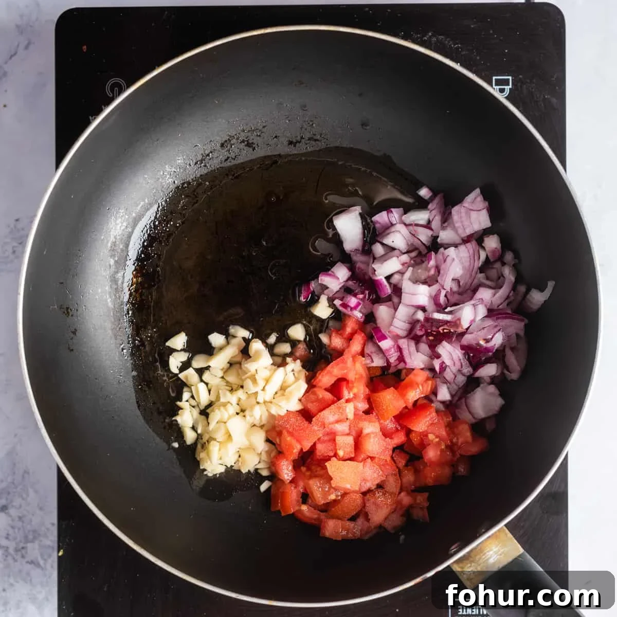 Gomen Wat: Spicy Ethiopian Collard Greens Recipe 5 Overhead view of a skillet pan with chopped onions, oil, garlic, and salt.