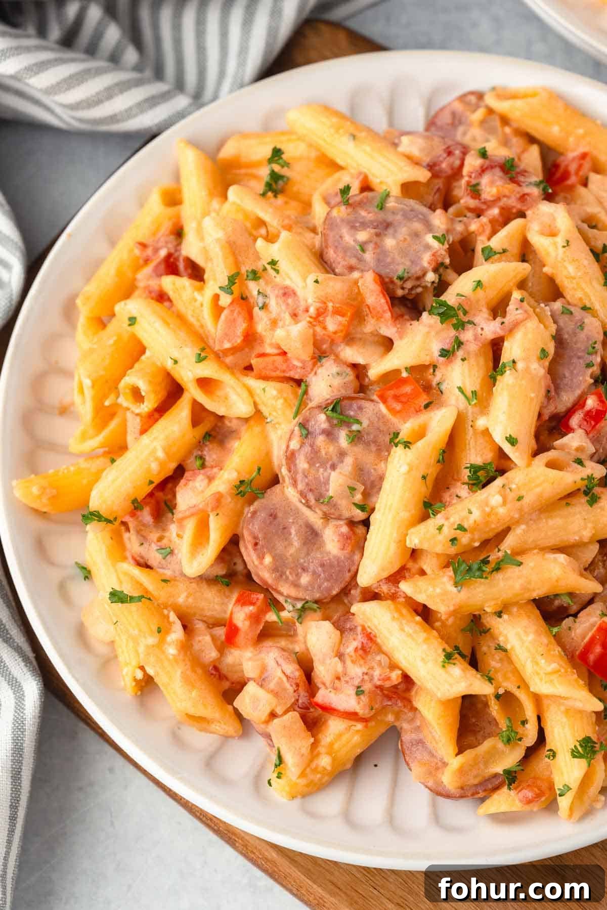 One-Pot Creamy Kielbasa and Smoked Sausage Pasta 2 Creamy kielbasa pasta with diced onion and bell peppers.