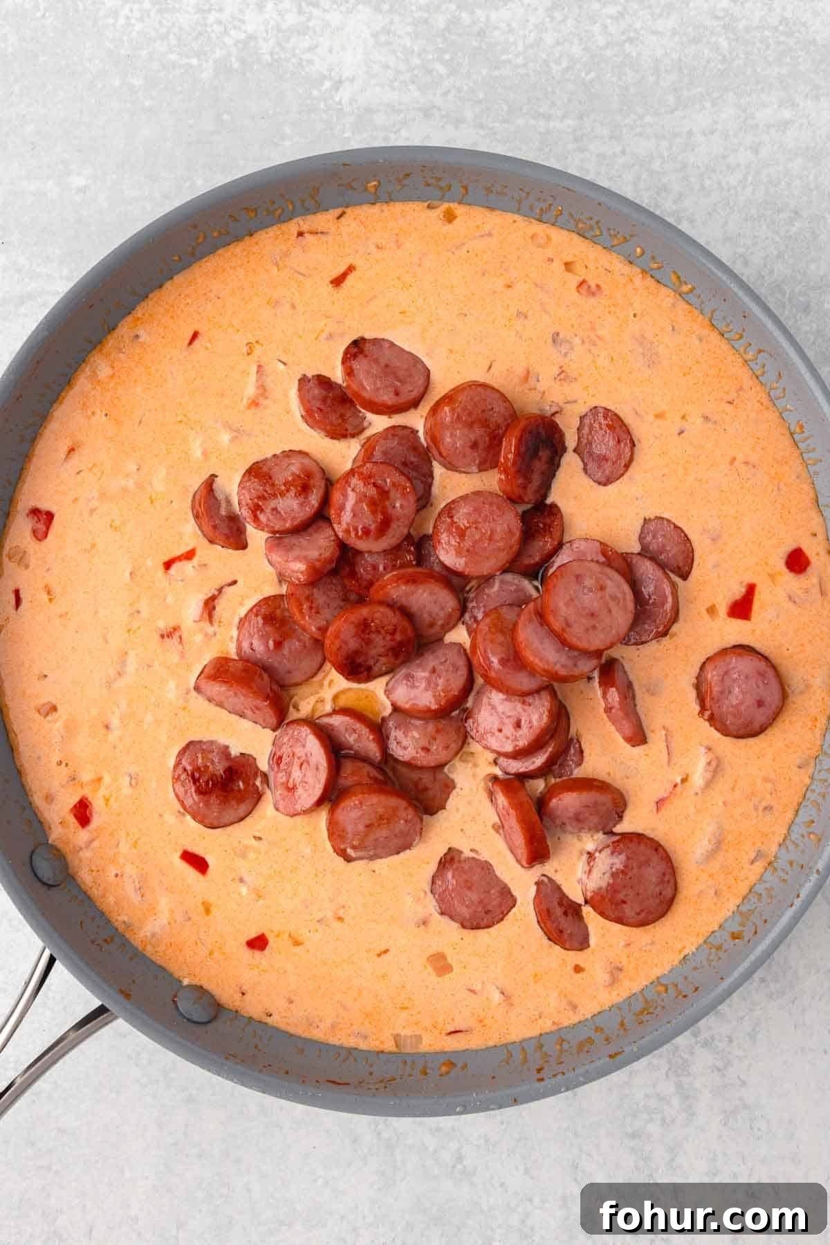 One-Pot Creamy Kielbasa and Smoked Sausage Pasta 8 The cooked slices of kielbasa are added back to the skillet with the sauce.
