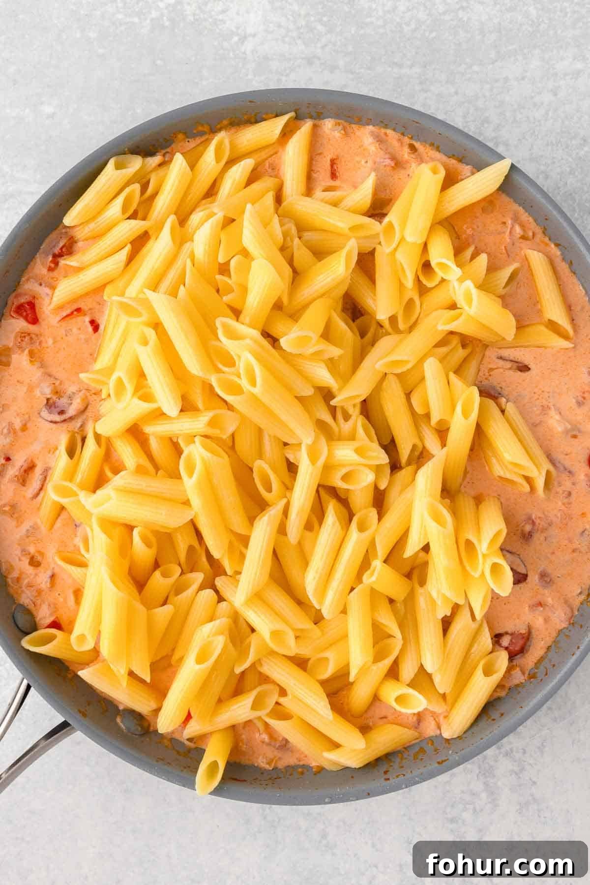 One-Pot Creamy Kielbasa and Smoked Sausage Pasta 9 Cooked pasta is added back to the skillet with the sausage and sauce.