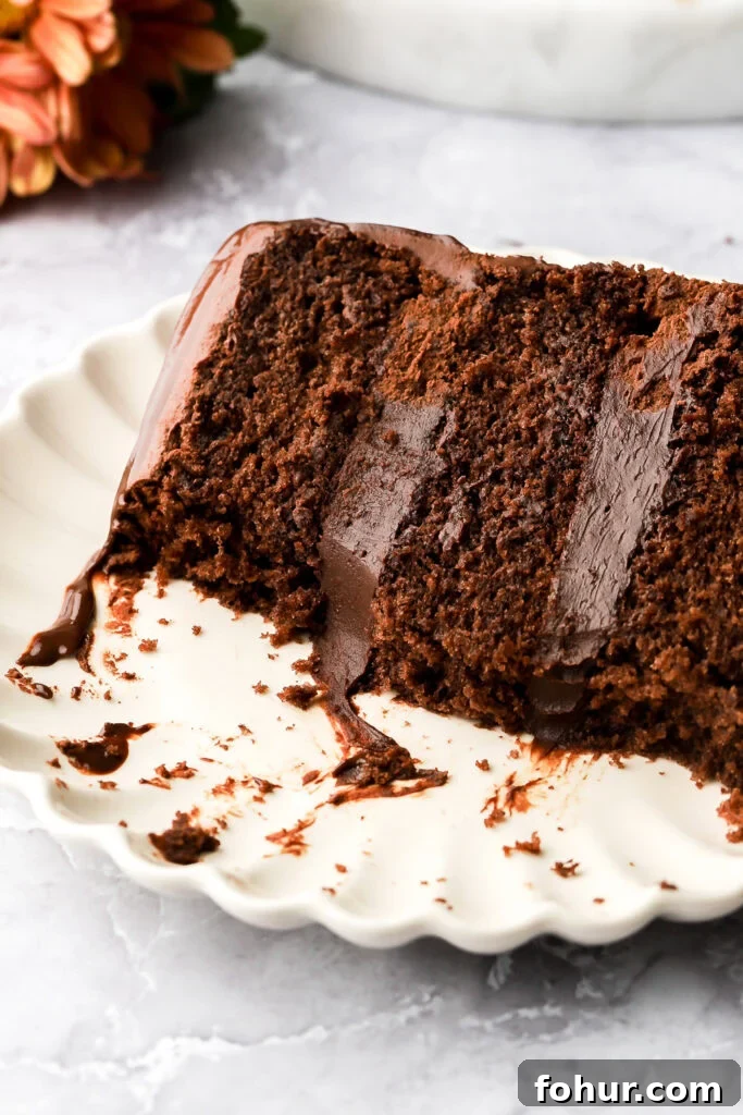Decadent Chocolate Ganache Cake Recipe 11 slice of chocolate ganache cake on a plate with a bite taken out