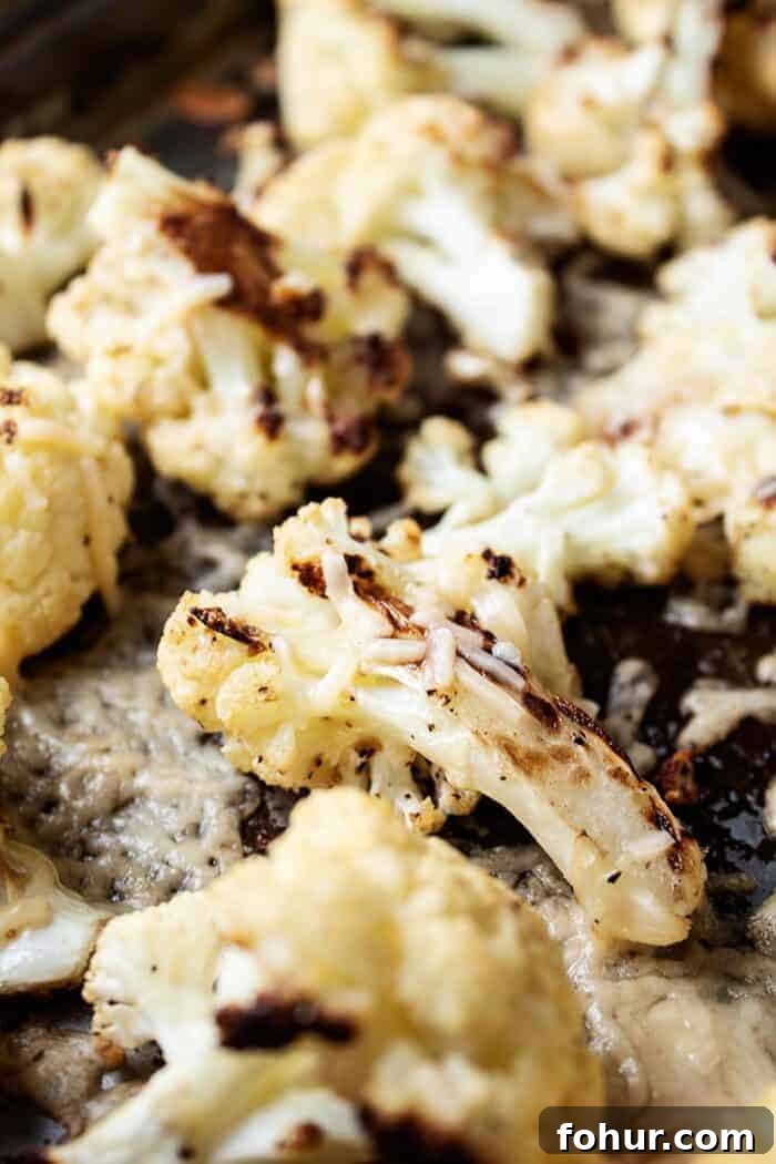 Crispy Keto Roasted Cauliflower with Parmesan 2 sheet pan with keto roasted cauliflower and melted parmesan cheese on it