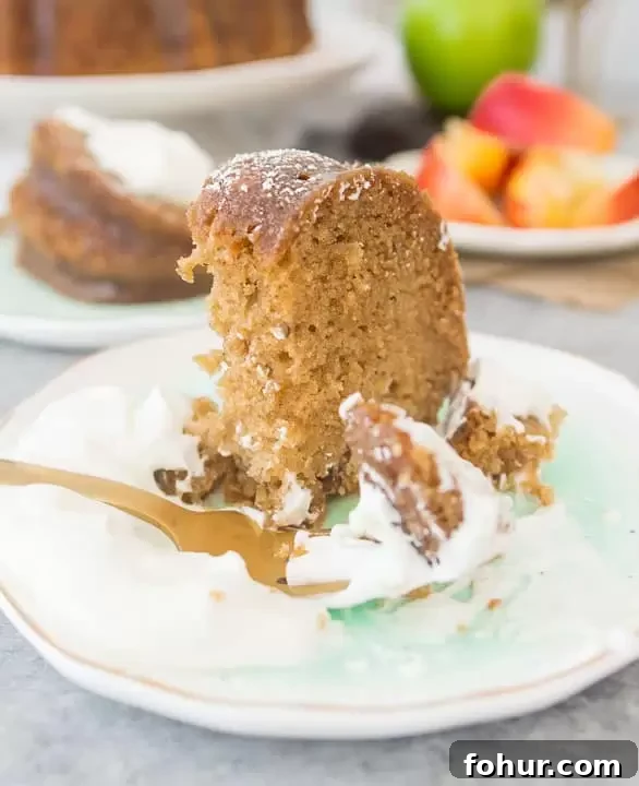 Moist Apple Bundt Cake with Warm Caramel Glaze 3 slice of fresh apple bundt cake on a plate with a fork taking a bite out of it