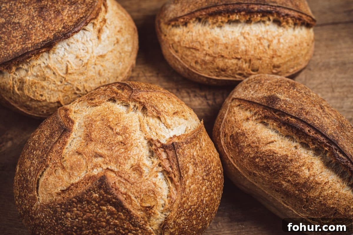 4 loaves of golden brown loaves of bread showing round and oval shapes - Hostess At Heart