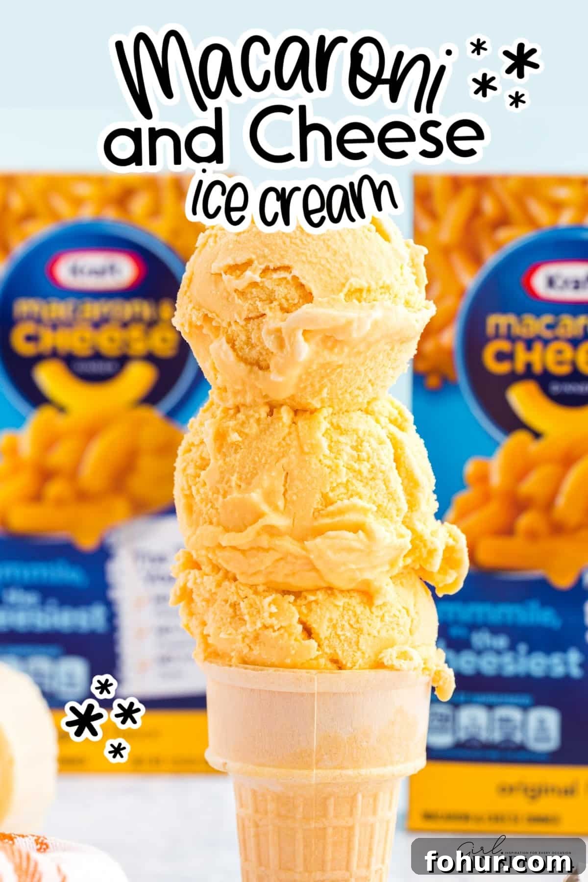 Copycat Mac and Cheese Ice Cream Recipe 2 Stack of scoops of Copycat Mac and Cheese Ice Cream, with boxes of Mac and Cheese in the back ground, with text overlay.