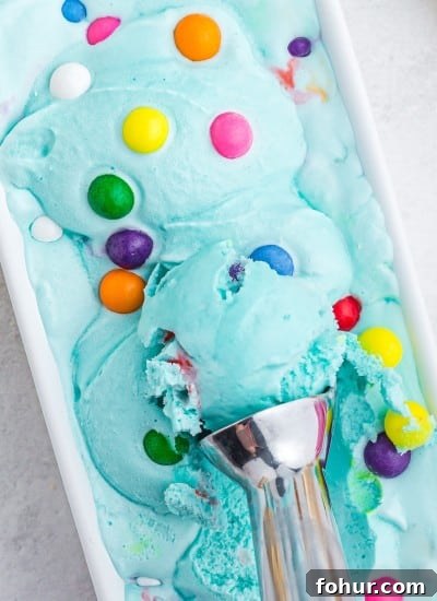 blue bubblegum ice cream with scoop in white loaf pan