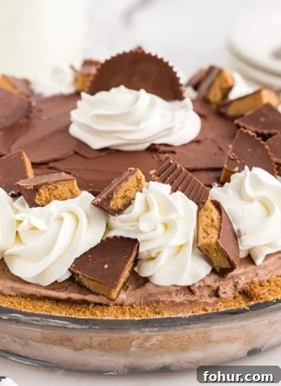 Glass pie dish filled with Peanut Butter Chocolate Ice Cream Pie on marble counter top