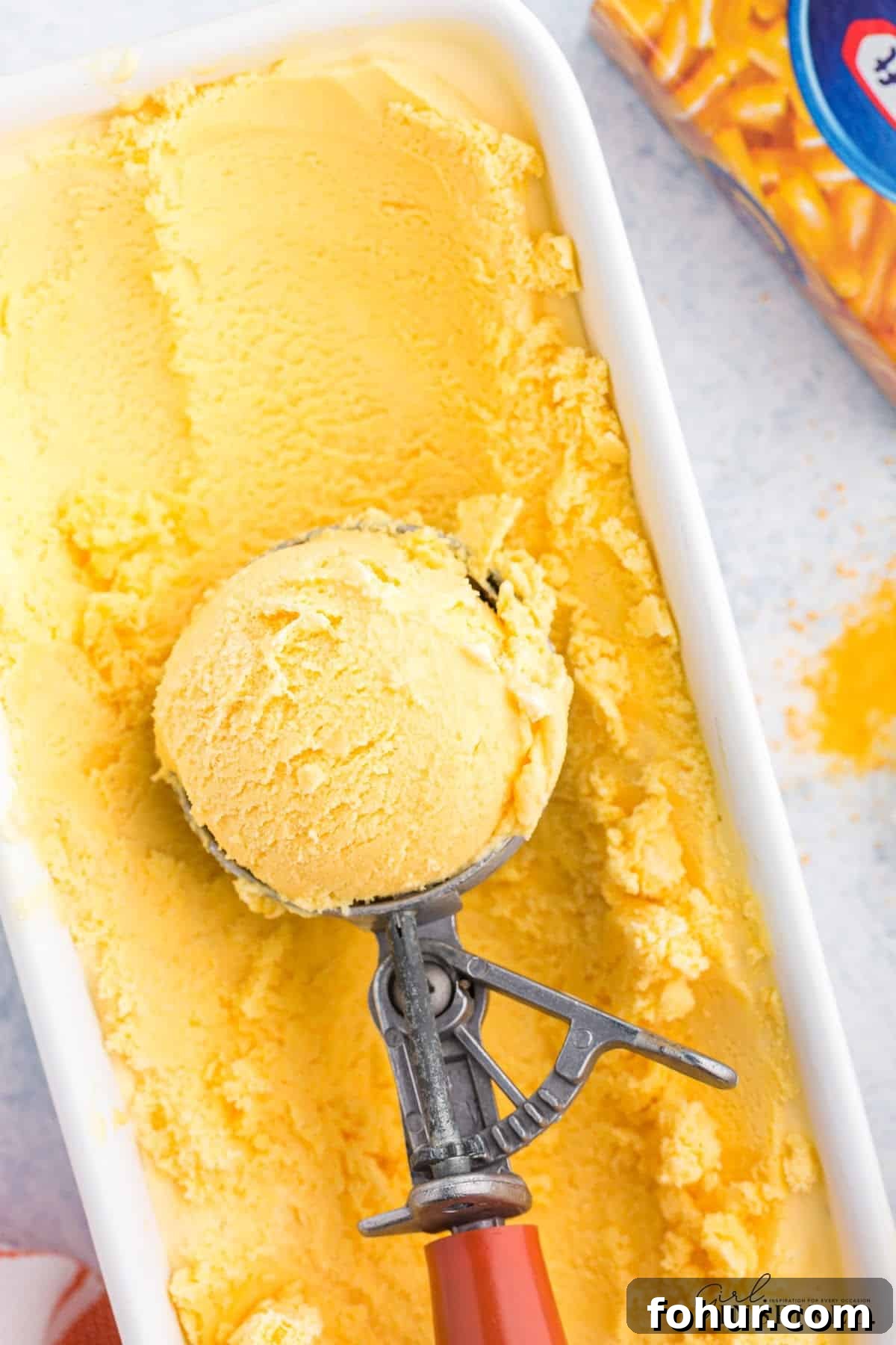 Copycat Mac and Cheese Ice Cream Recipe 10 Scooping the Mac and Cheese ice cream out of the bowl.