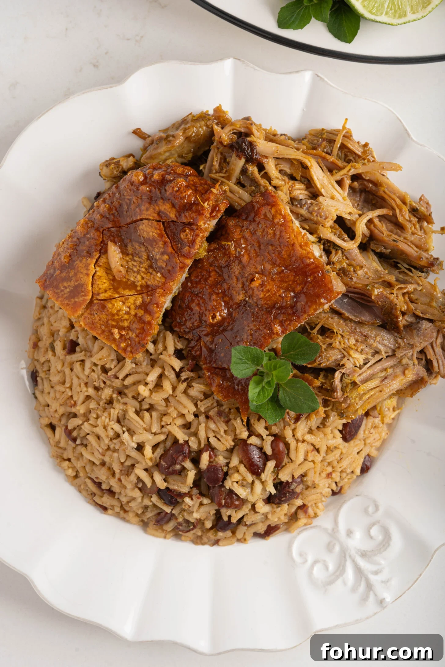 Crisp, Tender Puerto Rican Pernil: Roast Pork Shoulder 12 A plate of rice and beans with pernil.