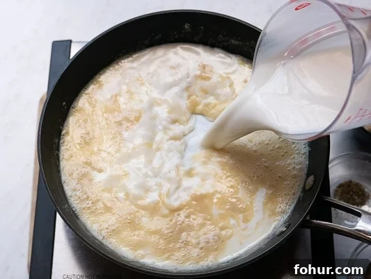 Creamy Fettuccine Alfredo: 30-Minute Vegetarian Recipe 5 Pouring milk into the garlic-butter mixture