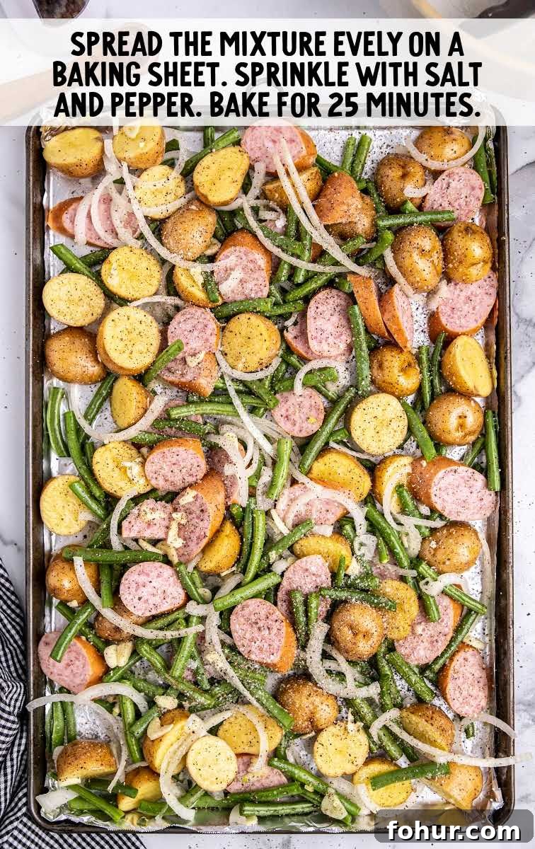 One-Pan Sausage, Green Bean and Potato Casserole 6 Sausage Green Bean Potato Casserole process shot of casserole spread in a baking sheet and topped with salt and pepper