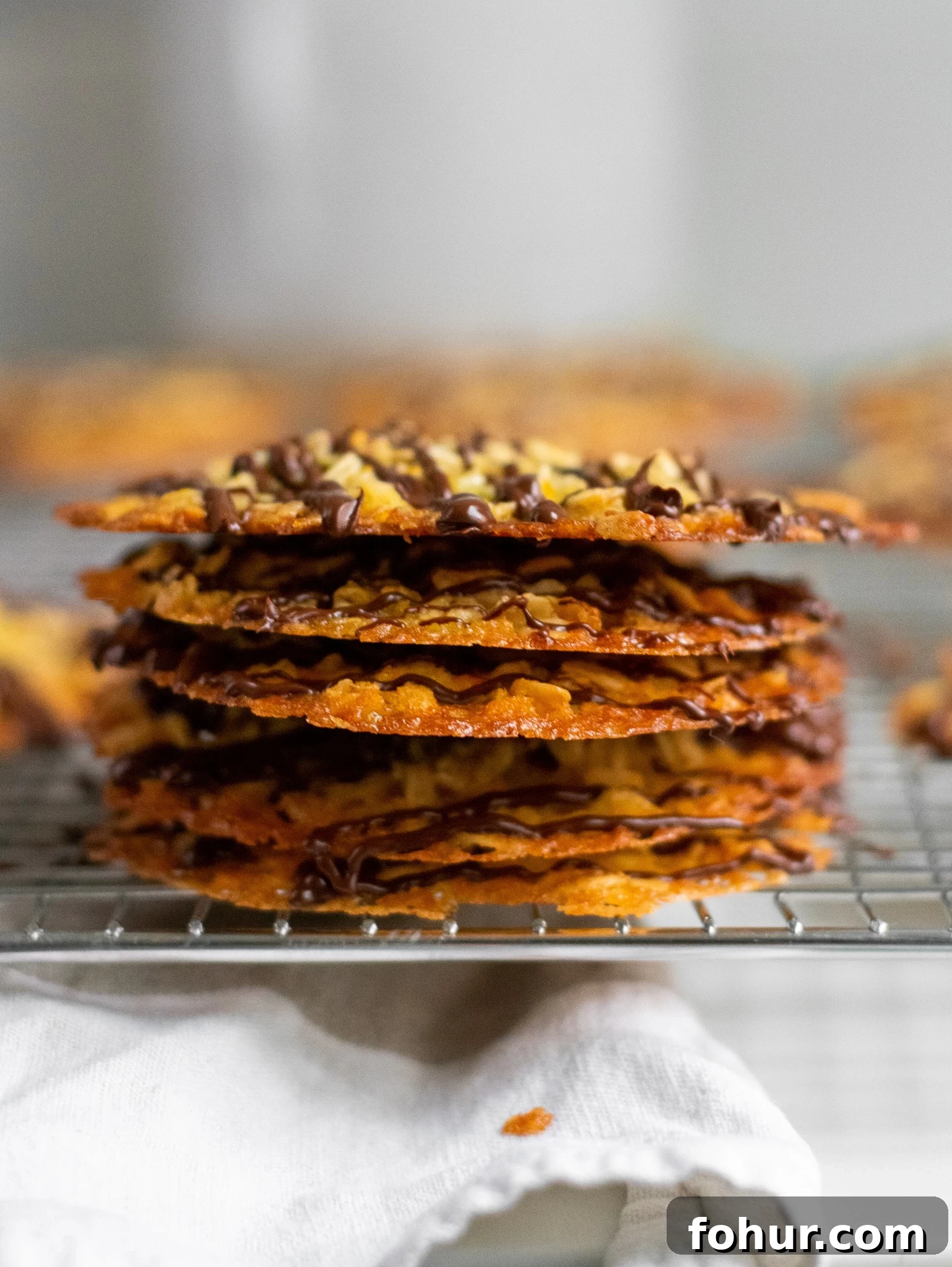 Homemade Oatmeal Cookies Recipe 2 A stack of oat cookies with chocolate drizzle.