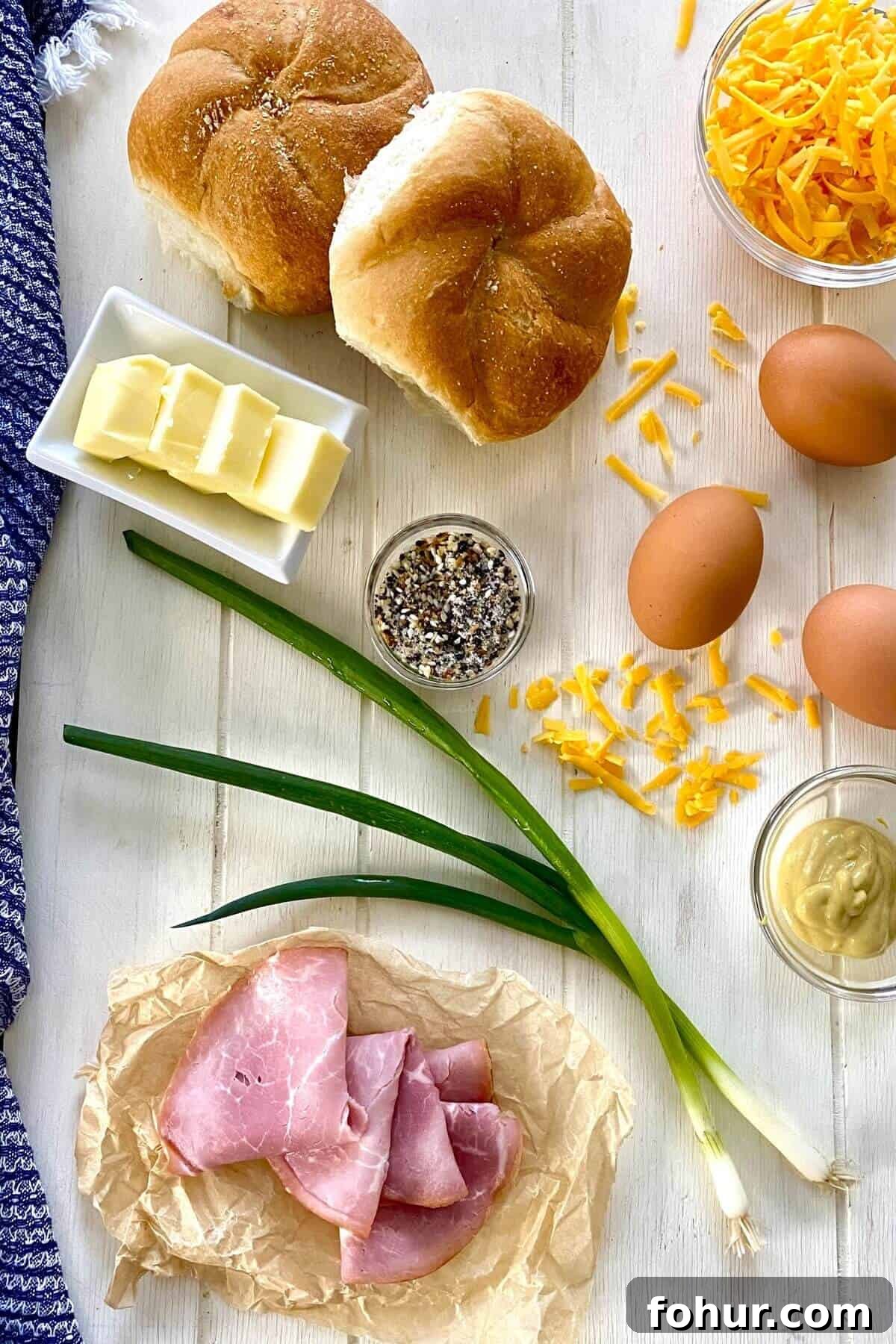 Baked Eggs in Mini Bread Rolls 3 eggs, ham, shredded cheese, rolls, butter, scallions.