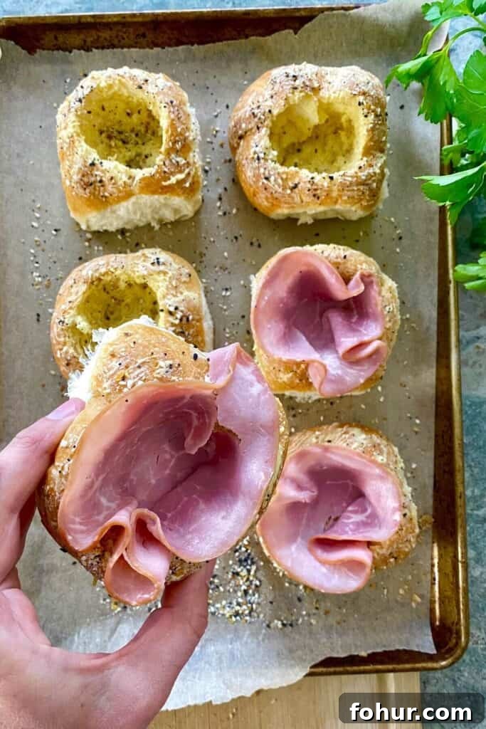 Baked Eggs in Mini Bread Rolls 6 bread bowls filled with ham.