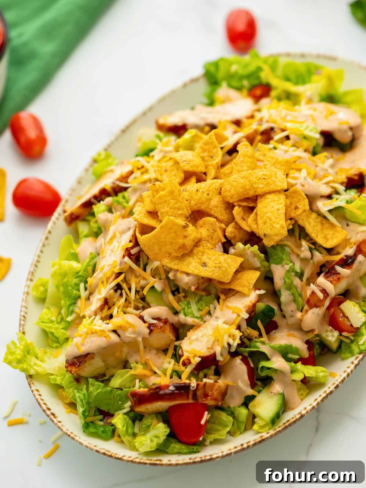 Bed of lettuce topped with BBQ Chicken, shredded cheese, corn chips, and BBQ Ranch Dressing.
